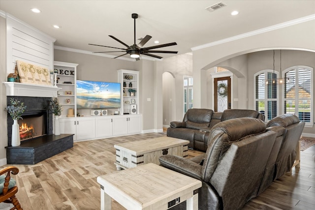 2141 Vanderbilt Dr, Weatherford, TX 76088 - living area with arched walkways, a ceiling fan, recessed lighting, light wood-type flooring, and ornamental molding
