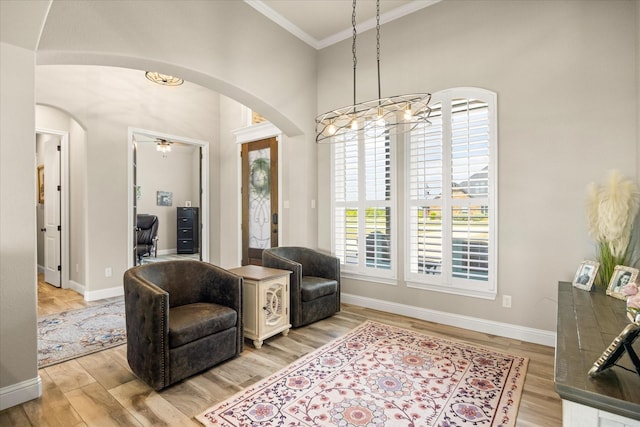 2141 Vanderbilt Dr, Weatherford, TX 76088 - living area featuring arched walkways, ornamental molding, a chandelier, baseboards, and a towering ceiling