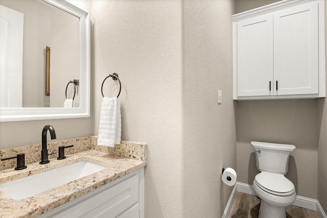 2141 Vanderbilt Dr, Weatherford, TX 76088 - half bathroom featuring vanity, toilet, wood finished floors, and baseboards