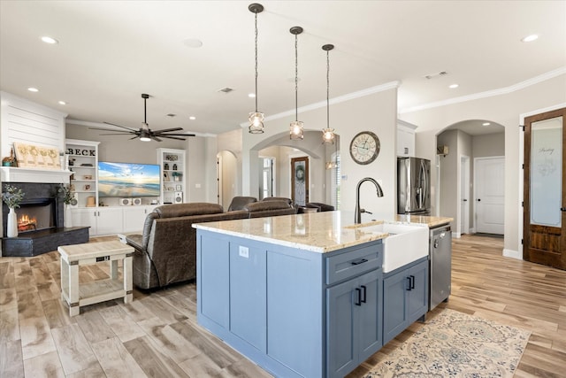 2141 Vanderbilt Dr, Weatherford, TX 76088 - kitchen featuring a sink, appliances with stainless steel finishes, arched walkways, crown molding, and light wood-style floors
