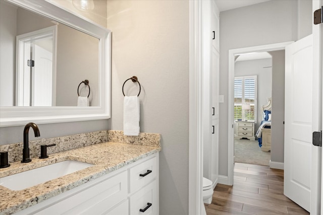 2141 Vanderbilt Dr, Weatherford, TX 76088 - bathroom featuring toilet, vanity, wood finished floors, and baseboards