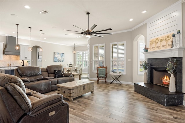 2141 Vanderbilt Dr, Weatherford, TX 76088 - living room with arched walkways, recessed lighting, light wood finished floors, crown molding, and ceiling fan