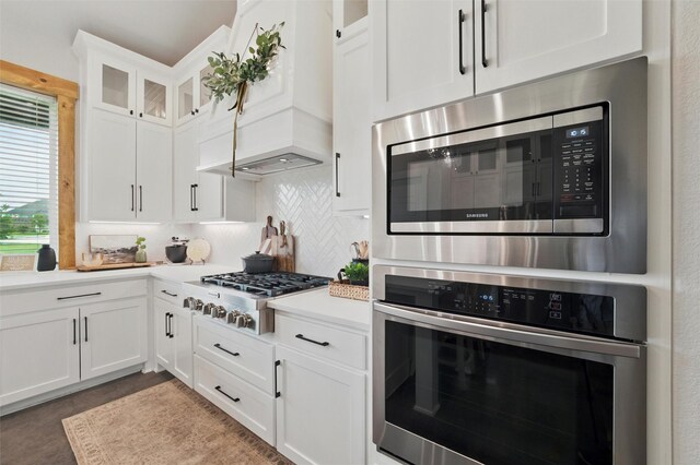 450 Cobb Ln, Waxahachie, TX 75167 - kitchen with stainless steel appliances, backsplash, custom exhaust hood, light countertops, and white cabinetry