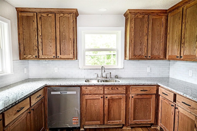 190 Trail Dr, Bowie, TX 76230 - kitchen with dishwasher, a sink, tasteful backsplash, and brown cabinets