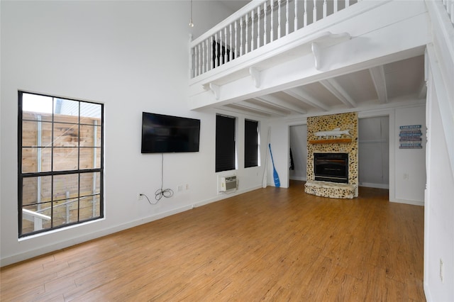 195 Cambridge Dr, Pottsboro, TX 75076 - unfurnished living room featuring beam ceiling, wood finished floors, a large fireplace, and baseboards