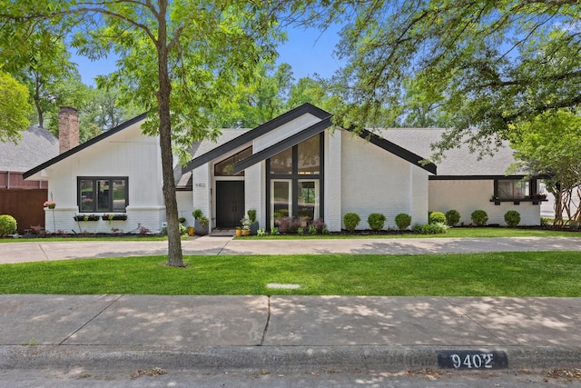9402 Spring Hollow Dr, Dallas, TX 75243 - mid-century modern home with brick siding, a front yard, and a chimney