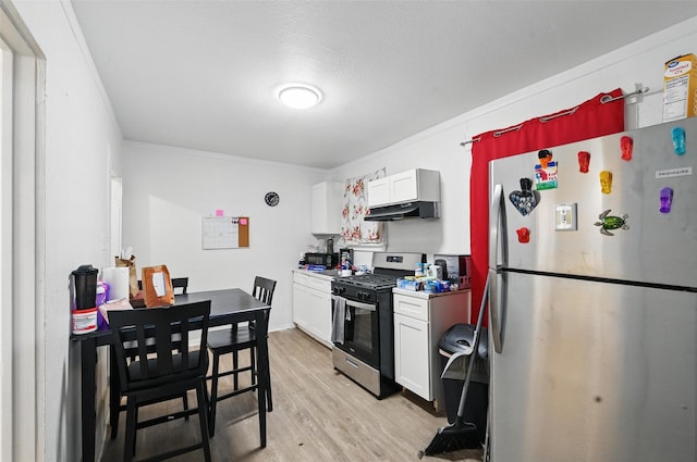 3950 Lisbon St, Fort Worth, TX 76107 - kitchen with stainless steel appliances, light wood finished floors, white cabinetry, under cabinet range hood, and light countertops