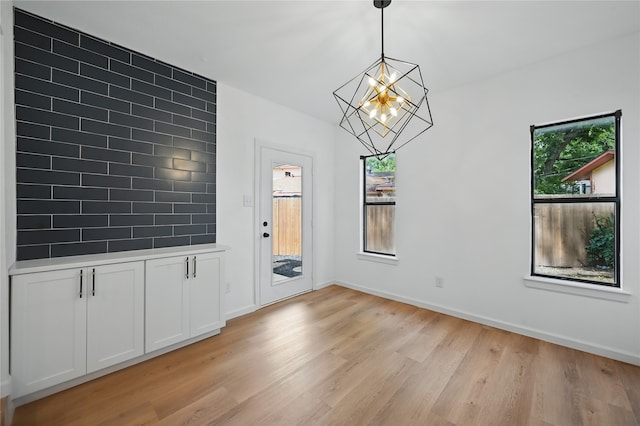 512 Shadowbrook Ln, Hurst, TX 76053 - unfurnished dining area featuring a chandelier, light wood-type flooring, healthy amount of natural light, and baseboards
