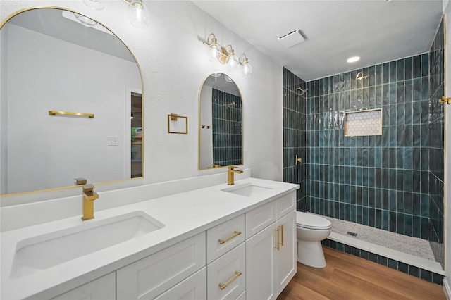 512 Shadowbrook Ln, Hurst, TX 76053 - full bathroom with toilet, tiled shower, double vanity, and wood finished floors