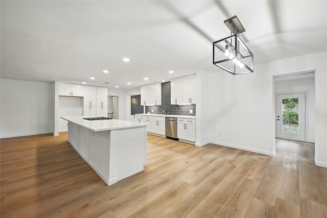 512 Shadowbrook Ln, Hurst, TX 76053 - kitchen featuring appliances with stainless steel finishes, white cabinetry, light countertops, decorative backsplash, and light wood-type flooring
