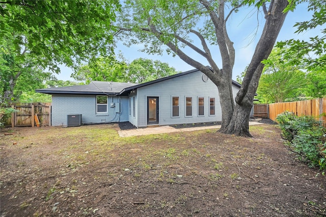 512 Shadowbrook Ln, Hurst, TX 76053 - rear view of house featuring central air condition unit, a fenced backyard, and brick siding