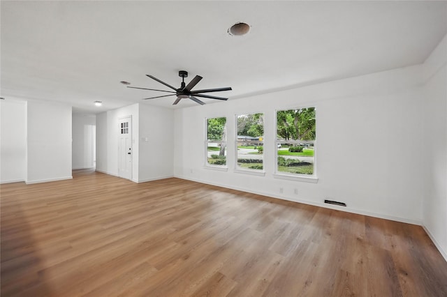 512 Shadowbrook Ln, Hurst, TX 76053 - unfurnished living room featuring light wood finished floors, a ceiling fan, and baseboards