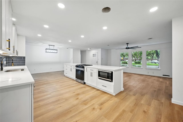 512 Shadowbrook Ln, Hurst, TX 76053 - kitchen with gas range, built in microwave, a sink, white cabinetry, and recessed lighting