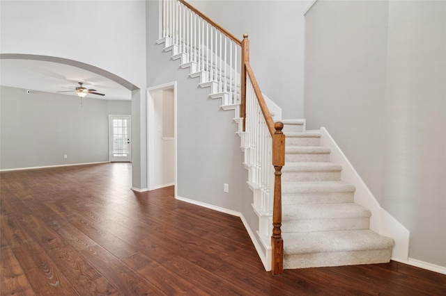 2125 Garden Crest Dr, Rockwall, TX 75087 - staircase with arched walkways, a ceiling fan, wood finished floors, a towering ceiling, and baseboards