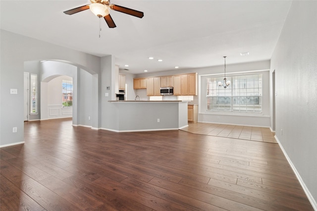 2125 Garden Crest Dr, Rockwall, TX 75087 - unfurnished living room with arched walkways, ceiling fan, wood-type flooring, a chandelier, and recessed lighting