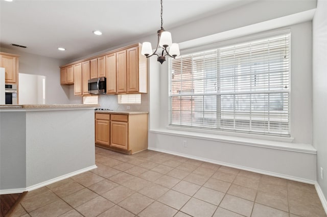 2125 Garden Crest Dr, Rockwall, TX 75087 - kitchen featuring stainless steel appliances, light countertops, a chandelier, light brown cabinetry, and baseboards