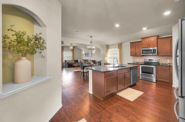3200 Keathley Dr, Waco, TX 76655 - kitchen featuring stainless steel appliances, a sink, dark countertops, open floor plan, and backsplash