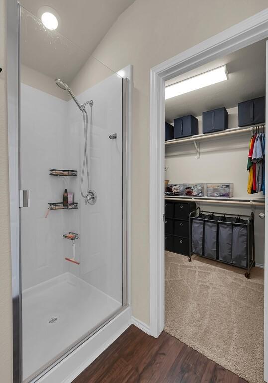 3200 Keathley Dr, Waco, TX 76655 - full bathroom featuring a stall shower, wood finished floors, a spacious closet, baseboards, and lofted ceiling