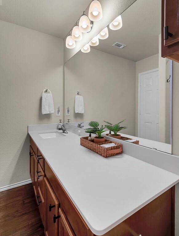 3200 Keathley Dr, Waco, TX 76655 - bathroom with double vanity, wood finished floors, and baseboards