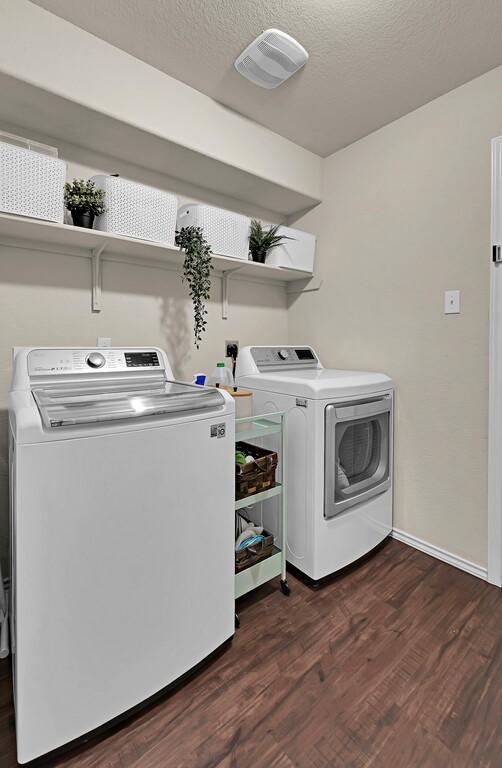 3200 Keathley Dr, Waco, TX 76655 - washroom with separate washer and dryer, dark wood-style flooring, baseboards, and a textured ceiling