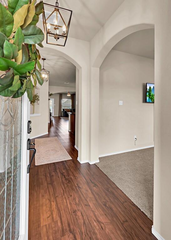 3200 Keathley Dr, Waco, TX 76655 - entryway featuring arched walkways, dark wood-style floors, baseboards, and a chandelier