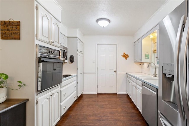 7844 Fairway Rd, Woodway, TX 76712 - kitchen with stainless steel appliances, a sink, white cabinetry, dark wood-type flooring, and a textured ceiling