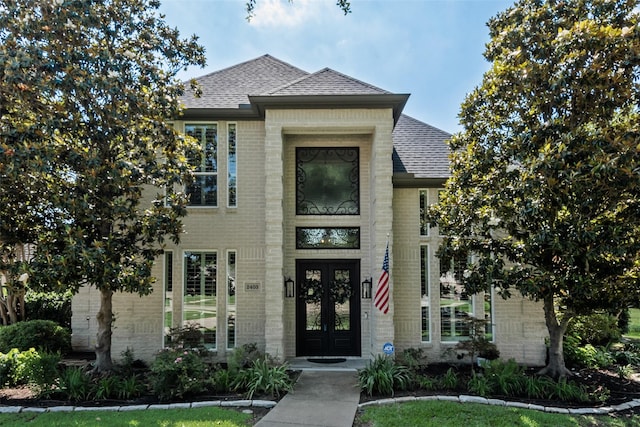 2403 Legend Dr, Heath, TX 75032 - french country inspired facade with brick siding, a shingled roof, and french doors