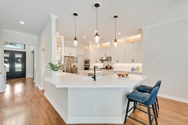 2403 Legend Dr, Heath, TX 75032 - kitchen featuring stainless steel appliances, under cabinet range hood, a sink, light wood-style flooring, and ornamental molding