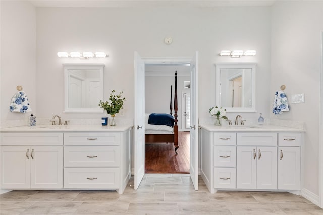2403 Legend Dr, Heath, TX 75032 - ensuite bathroom featuring two vanities, wood tiled floors, and baseboards