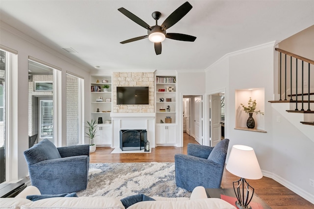 2403 Legend Dr, Heath, TX 75032 - living room with a ceiling fan, wood finished floors, a fireplace with flush hearth, ornamental molding, and stairway