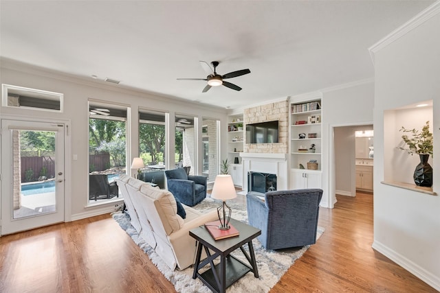 2403 Legend Dr, Heath, TX 75032 - living room featuring a ceiling fan, a fireplace, crown molding, light wood-style floors, and baseboards