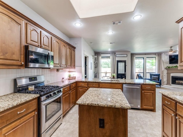 3033 Maple Creek Dr, Fort Worth, TX 76177 - kitchen featuring stainless steel appliances, a peninsula, light tile patterned floors, a kitchen island, and open floor plan