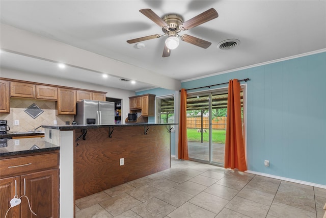 3209 N Calais St, Sherman, TX 75090 - kitchen featuring stainless steel refrigerator with ice dispenser, tasteful backsplash, a breakfast bar, ceiling fan, and baseboards