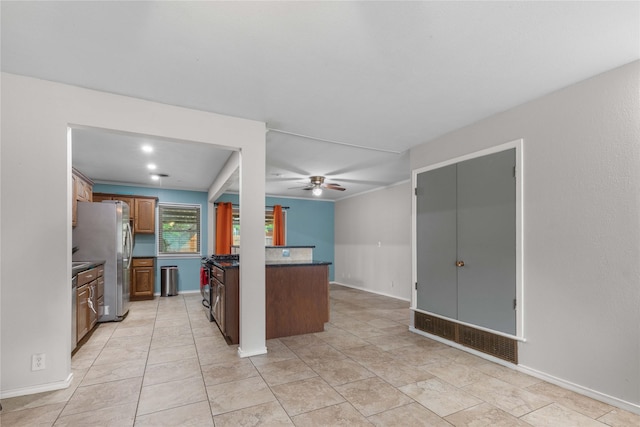 3209 N Calais St, Sherman, TX 75090 - kitchen featuring freestanding refrigerator, a ceiling fan, dark countertops, brown cabinets, and baseboards