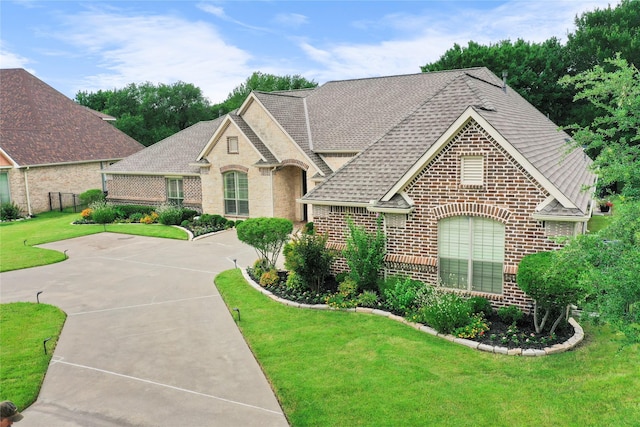 3042 Preston Club Dr, Sherman, TX 75092 - french country inspired facade featuring brick siding, roof with shingles, and a front lawn