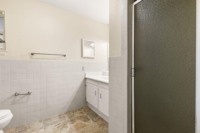 281 Lakeside Dr, China Spring, TX 76633 - bathroom featuring tile walls, vanity, toilet, a shower stall, and wainscoting