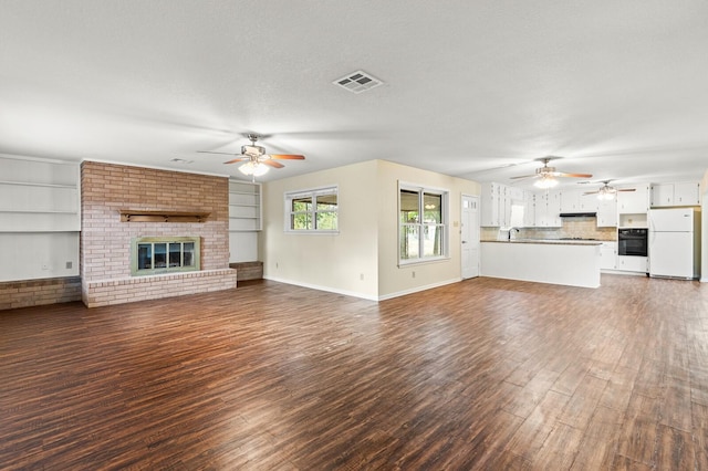 281 Lakeside Dr, China Spring, TX 76633 - unfurnished living room featuring ceiling fan, wood finished floors, and a brick fireplace