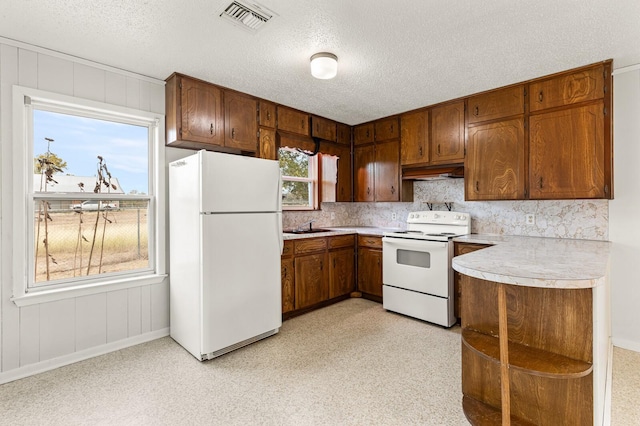 281 Lakeside Dr, China Spring, TX 76633 - kitchen with white appliances, under cabinet range hood, light countertops, a sink, and a textured ceiling