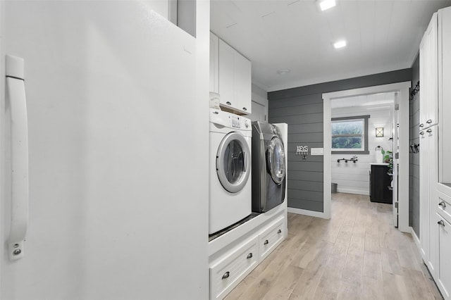 4009 Seminole Trl, Granbury, TX 76048 - washroom with washing machine and clothes dryer, cabinet space, and light wood-type flooring