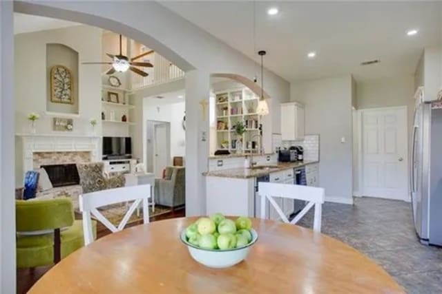 14 E Hillside Pl, Trophy Club, TX 76262 - dining area featuring arched walkways, ceiling fan, a fireplace, built in features, and recessed lighting