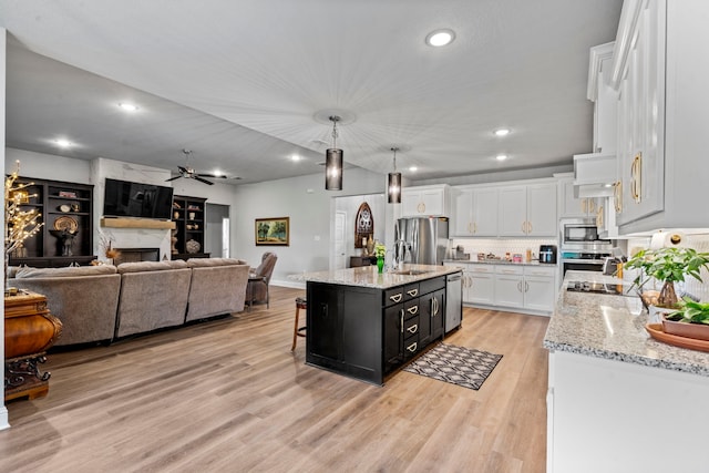 105 Aslan Rd, Poolville, TX 76487 - kitchen with appliances with stainless steel finishes, white cabinetry, light wood finished floors, a breakfast bar, and ceiling fan
