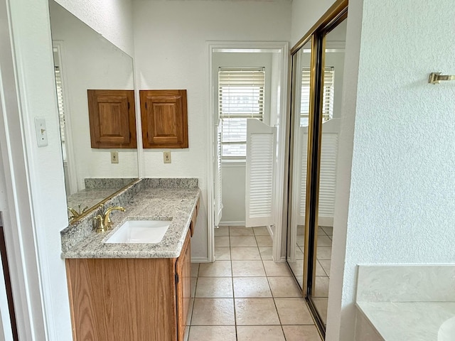 617 Desoto Dr, Desoto, TX 75115 - full bathroom with vanity, a textured wall, tile patterned flooring, and baseboards