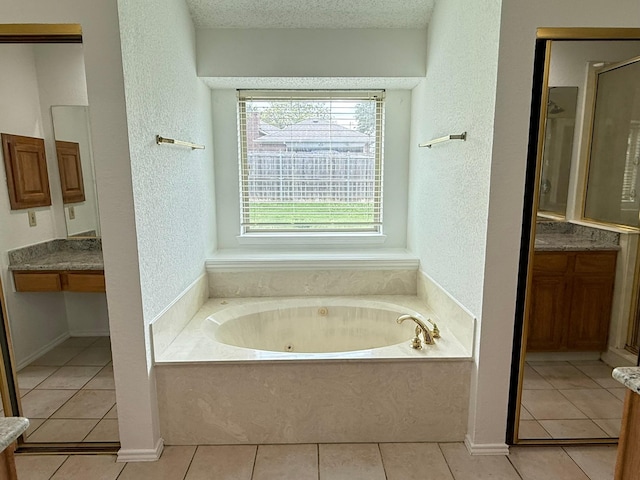 617 Desoto Dr, Desoto, TX 75115 - full bathroom featuring a textured wall, a tub with jets, tile patterned floors, and vanity