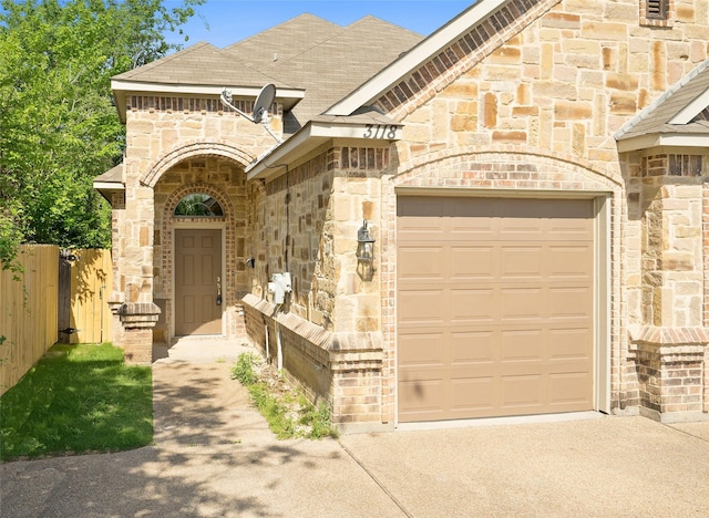 3116 Frazier Ave, Fort Worth, TX 76110 - french country inspired facade featuring stone siding, concrete driveway, an attached garage, and roof with shingles