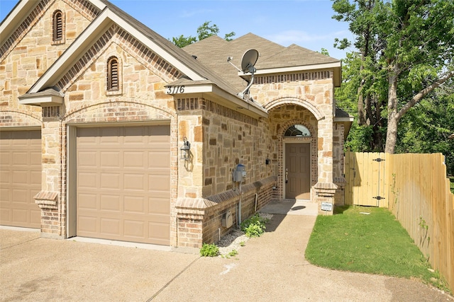3116 Frazier Ave, Fort Worth, TX 76110 - french country home featuring stone siding, a garage, and brick siding