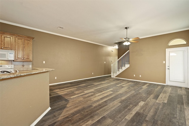 3116 Frazier Ave, Fort Worth, TX 76110 - unfurnished living room featuring ornamental molding, a ceiling fan, baseboards, dark wood finished floors, and stairs