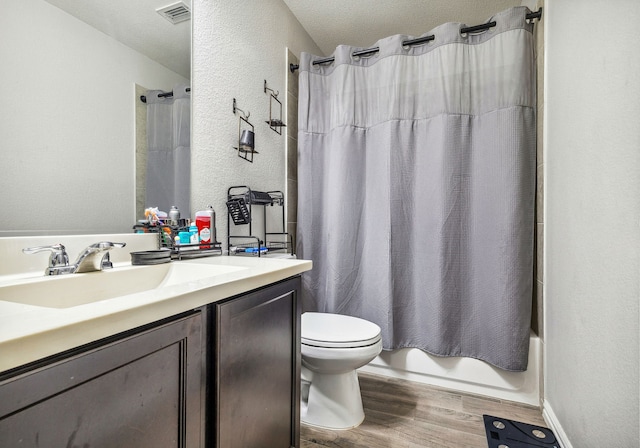 404 Madrone Ln, Princeton, TX 75407 - bathroom featuring wood finished floors, vanity, toilet, shower / bath combination with curtain, and a textured wall