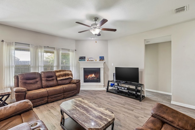 404 Madrone Ln, Princeton, TX 75407 - living room featuring a ceiling fan, light wood finished floors, baseboards, and a glass covered fireplace