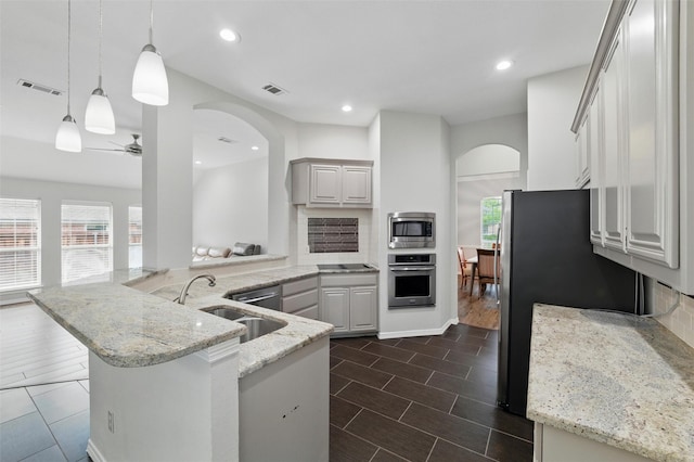 3402 Blue Forest Dr, Arlington, TX 76001 - kitchen with appliances with stainless steel finishes, arched walkways, a sink, light stone countertops, and recessed lighting
