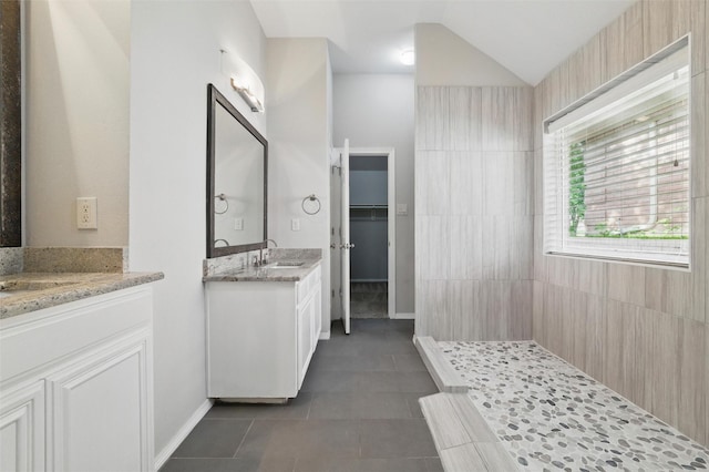 3402 Blue Forest Dr, Arlington, TX 76001 - bathroom with two vanities, tiled shower, tile patterned flooring, vaulted ceiling, and baseboards